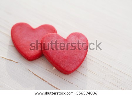 Two red hearts on a wooden white background, soft focus. Romantic card. Declaration of love in vintage style. Gift by St. Valentine's Day. 