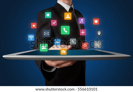 Businessman holding tablet with colorful applications