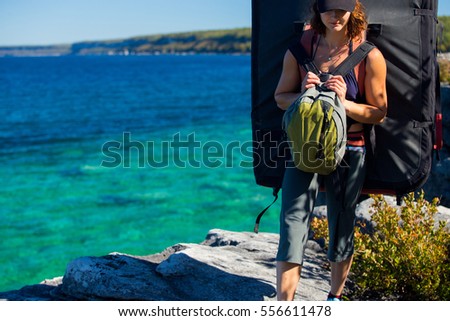 A beautiful woman goes bouldering while rock climbing on the shore line of the Great Lakes. 