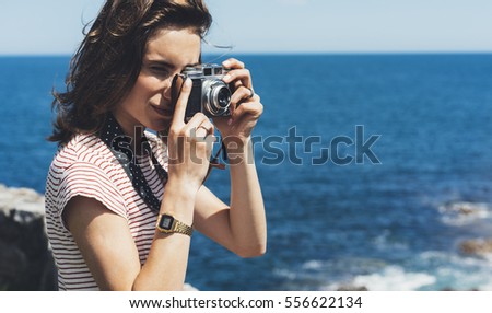 Tourist traveler photographer making pictures sea scape on vintage photo camera on background yacht and boat piar, hipster girl enjoying nature holiday, mockup ocean waves view, blurred backdrop