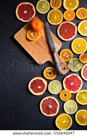 Sliced fruits background with dark background. Orange, grapefruit, lemon and mandarin
