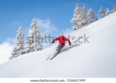 Freeride skiier riding in deep powder snow Royalty-Free Stock Photo #556667449