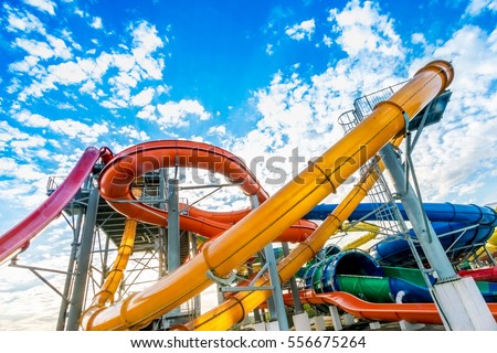 Colourful plastic slides in aquapark Royalty-Free Stock Photo #556675264