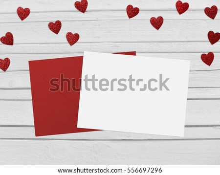 Valentines day or wedding mockup scene with red envelope, blank card, glittering paper hearts confetti and wooden background. Empty space for your text, top view.