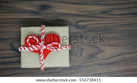gift box with red heart shape and wooden table. 
