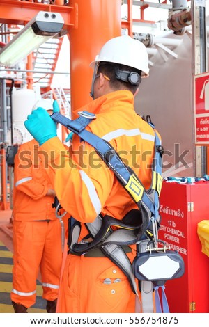 Electrician operator with safety harness inspect and checking Fire and gas detection. Fire and gas detection monitoring system in hazardous area in oil and gas central processing platform.