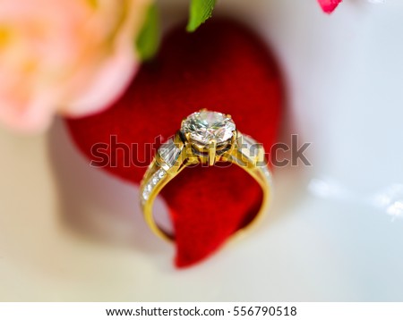 Diamond ring with red heart in a white heart shape bowl among red roses, concept for Valentine's day gift and Anniversary gift.  Represent for forever love, Isolated on white background.