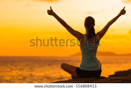 Healthy woman celebrating during a beautiful sunset. Happy and Free. Royalty-Free Stock Photo #556808413