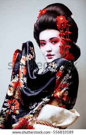 young pretty geisha in black kimono among sakura, asian ethno
