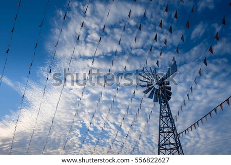 Silhouette festival flag line decoration and wind turbines on sky background
