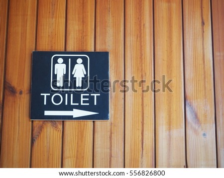 Toilet sign appears everywhere and it is universal language. Black toilet plate which has white image is attached with wooden screen.