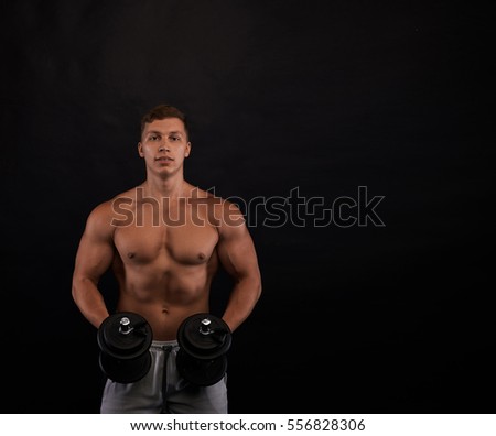 Strong body of european man training with dumbbel on black background. Fitness man working. Copy space for advertising text