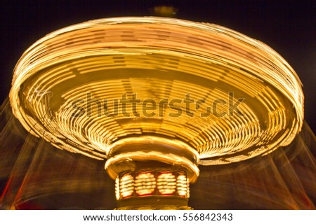 The swings on a high speed merry-go-round appear to go into hyperdrive in the summer night sky at an amusement park in this time lapse photo.