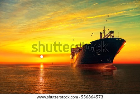 Oil tanker ship at sea on a background of sunset sky. Royalty-Free Stock Photo #556864573
