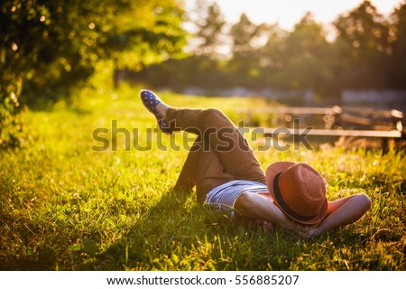 Trendy Hipster Girl Relaxing on the Grass Royalty-Free Stock Photo #556885207