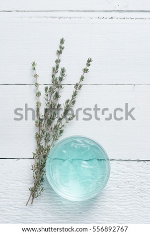 menthol cosmetic gel and thyme twigs on white wooden table 