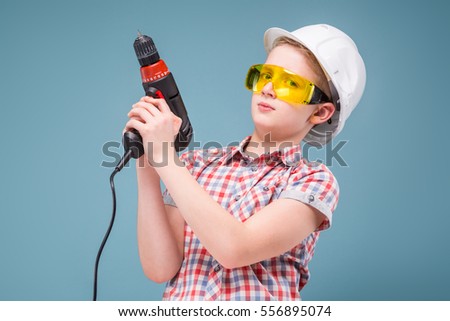 half-length studio portrait of an inexperienced schoolboy builder with screwdriver in hand