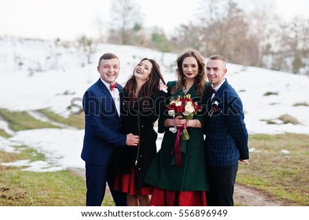 Cheerful best mans with bridesmaids on winter wedding day.