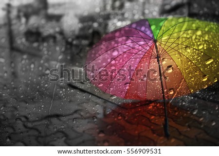 Blurry of umbrella ,view through the window on rainy day.  Royalty-Free Stock Photo #556909531