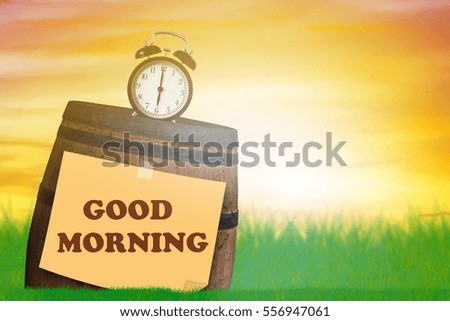 Good morning and wake up concept, alarm clock and wood barrel on green grass