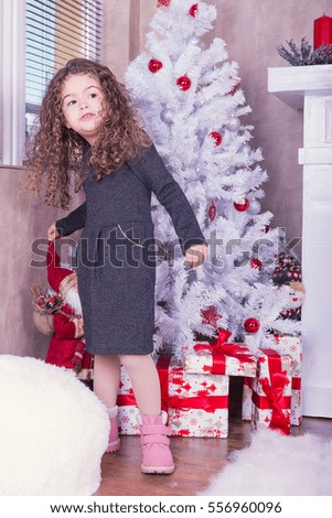 Portrait of pretty little girl near a fireplace in Christmas