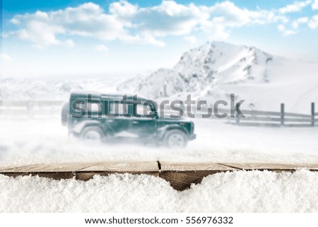 wooden table of free space and winter car in snow 