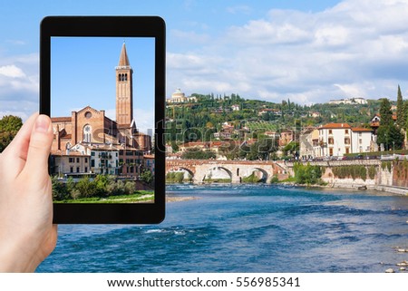 travel concept - tourist photographs Sant Anastasia Church and Ponte Pietra bridge in Verona city on tablet in Italy