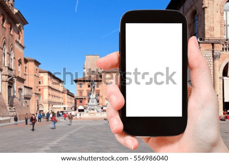 travel concept - tourist photographs square in Bologna city on smartphone with cut out screen with blank place for advertising in Italy
