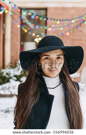 Portrait of happy elegant girl with Snowflakes. Magic colorful lights on background. 