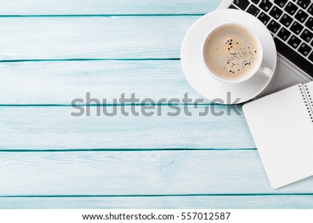 Desk table with laptop, coffee and notepad on wooden table. Workplace. Top view with copy space.