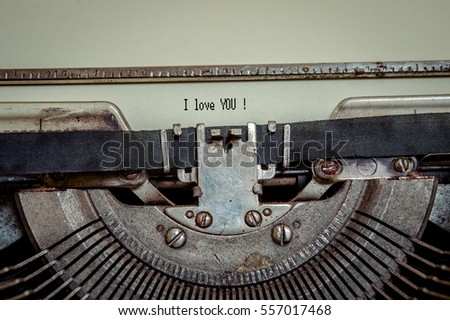 Close up image of Typewriter with moving typebar and paper sheet with message I love You  printed on typewriter machine.  Space for your text. Vintage retro writing machine. 