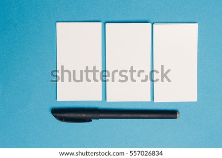 business card on a blue background and a pen