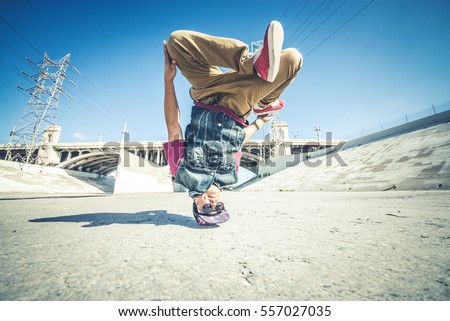  Bboy doing some stunts - Street artist breakdancing outoodrs Royalty-Free Stock Photo #557027035