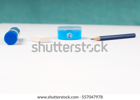 Pencil sharpener and elastic on the white paper. Back to school.