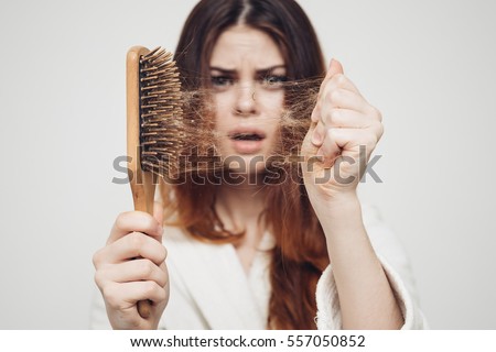 girl with a comb and problem hair on white background Royalty-Free Stock Photo #557050852