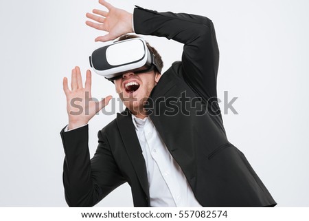 Picture of happy businessman standing at studio wearing 3d glasses virtual reality. Isolated over white background.