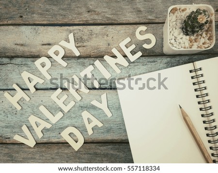 Happy valentines day alphabet, notebook, pencil and cactus on old wood table, process vintage tone