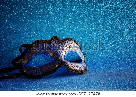 Image of elegant venetian mask on blue glitter background