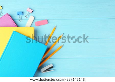 Colorful notebooks and office supplies on wooden background Royalty-Free Stock Photo #557145148
