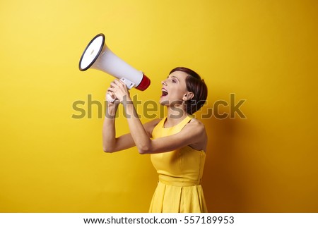 Female model using bullhorn in photo session Royalty-Free Stock Photo #557189953