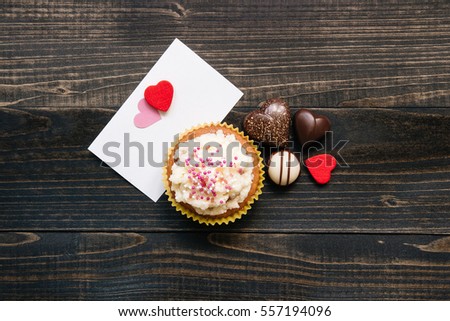 Valentine's Day background. Valentine's day card, chocolate and cupcake on the dark background
