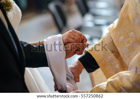 bride and groom holding each others hands in church