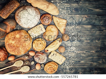 
Bread, rolls, pastries, croissants, eggs, on a dark wooden table. Royalty-Free Stock Photo #557265781