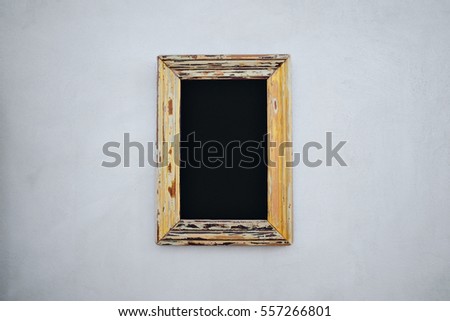 Empty chalkboard in a vintage wide frame with peeled paint on white background