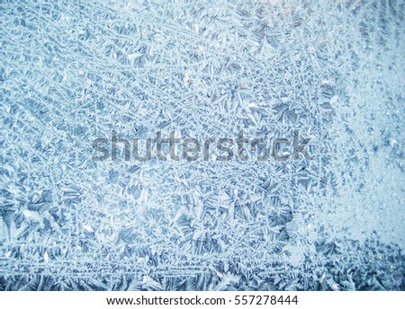 Light bright blue white frost snowflake beautiful pattern on the glass window inside the house. Winter season themed picture - cold season scene empty background wallpaper with copyspace for text