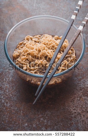 Soup Ramen noodles in glass bowl and on the gray table vertical