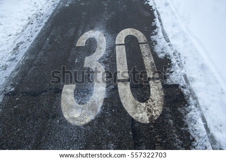 speed limit sign on a road covered with snow and ice