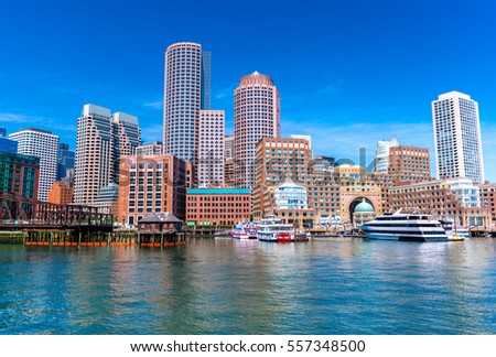 Boston cityscape reflected in water, skyscrapers and office buildings in downtown, view from Boston harbor, Massachusetts, USA