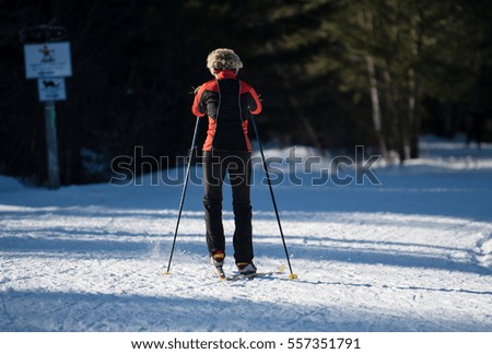 Female  cross country skiing on a trail in the woods