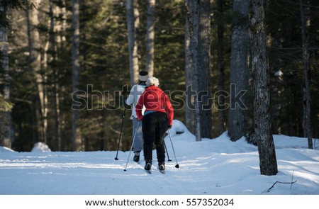 Friends cross country skiing on a trail in the woods